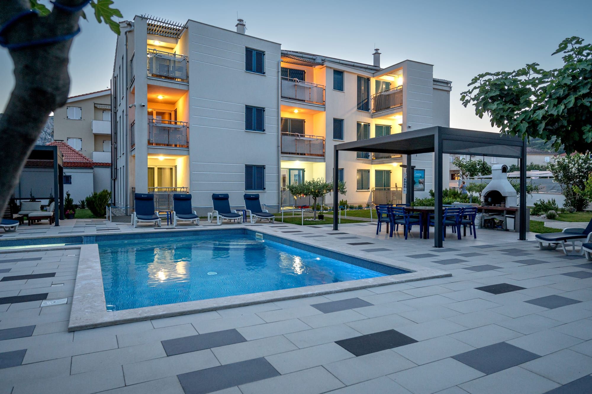 Adorami Apartments — pool and apart-house at dusk, Baška, island of Krk